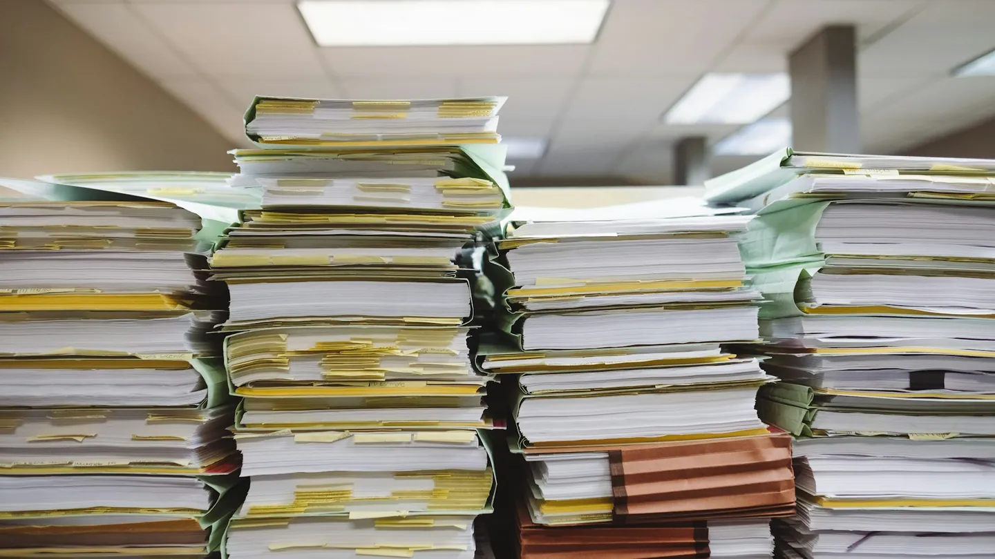 Pilas de documentos y carpetas de archivo.