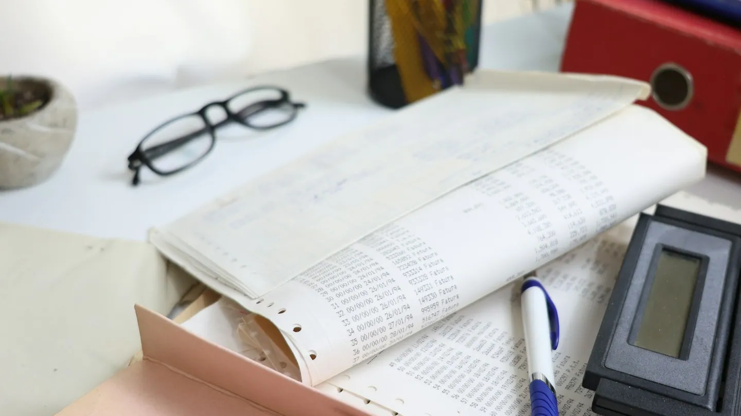 Documentos y calculadora sobre una mesa de trabajo.