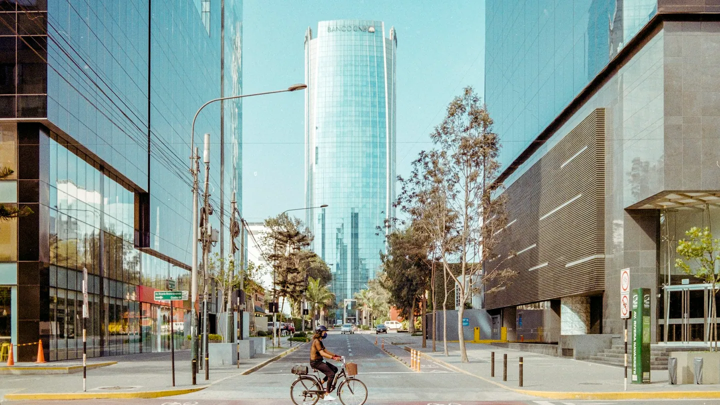 Un ciclista recorre una calle arbolada de San Isidro, Lima.