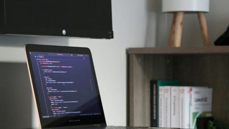 Computadora portátil con código en un escritorio.